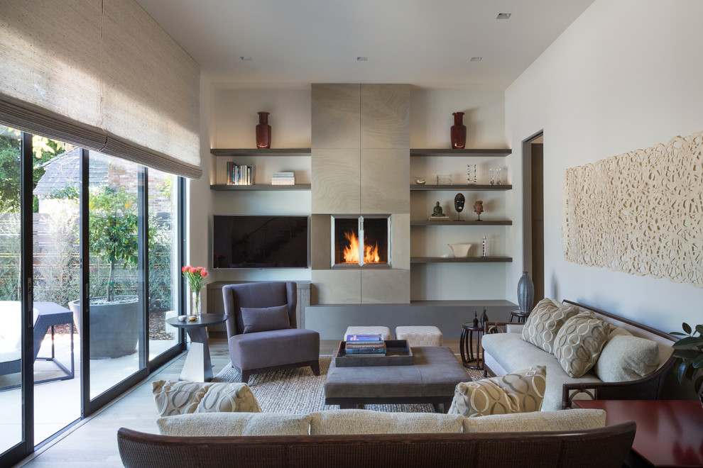 Cette image montre un salon design avec une salle de réception, un mur blanc, une cheminée standard, un téléviseur fixé au mur et un sol en bois brun.