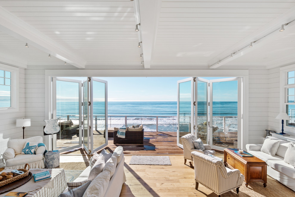 Idee per un grande soggiorno stile marino aperto con pareti bianche e parquet chiaro