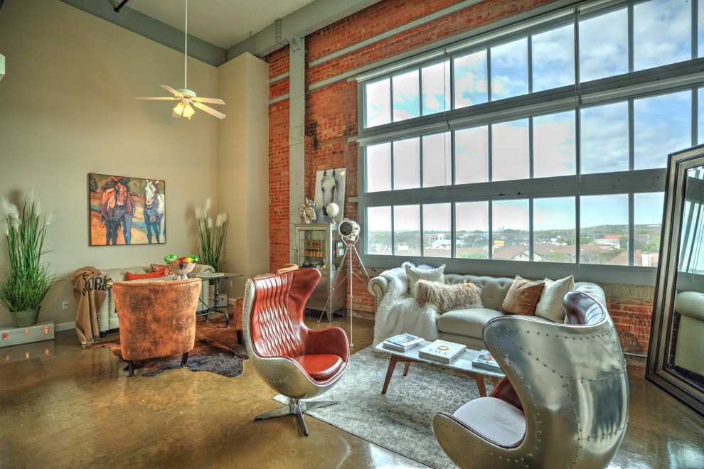 Urban open plan living room in Austin with red walls, concrete flooring, brown floors and brick walls.