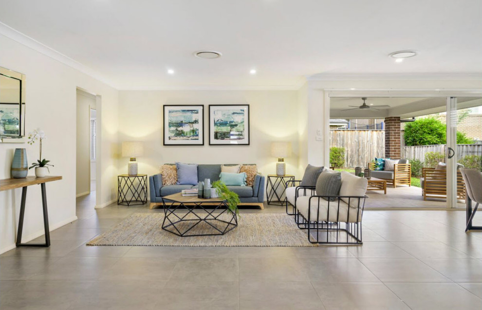Foto di un grande soggiorno design aperto con pareti beige, pavimento con piastrelle in ceramica e pavimento beige
