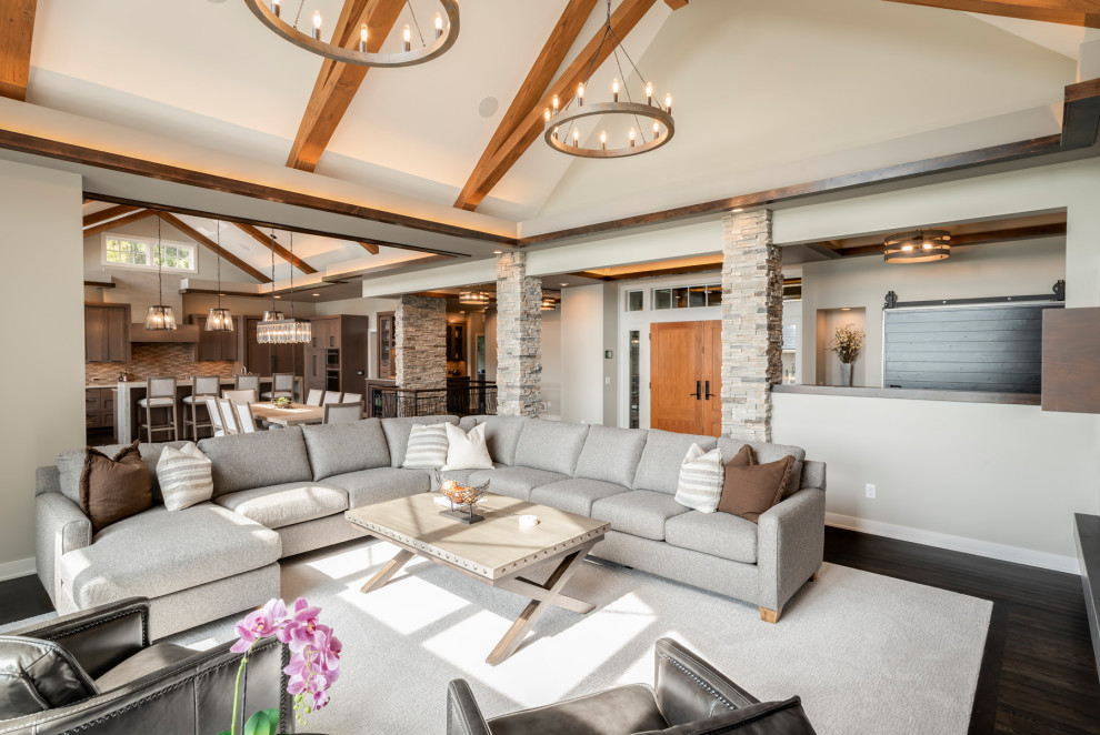 Example of a transitional open concept dark wood floor, brown floor, exposed beam and vaulted ceiling living room design in Minneapolis with gray walls