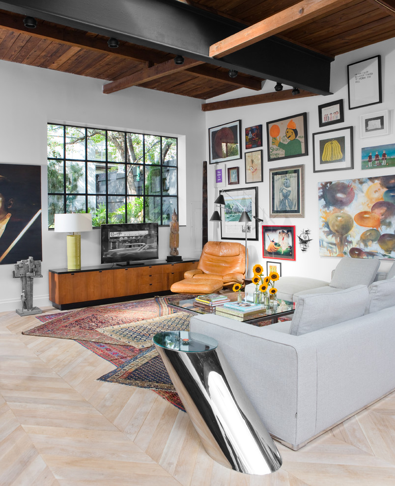 Foto de salón abierto industrial de tamaño medio sin chimenea con paredes blancas, televisor independiente, suelo de madera clara y suelo beige
