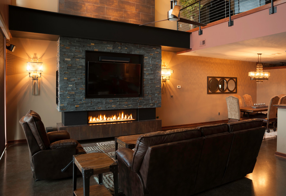 ウィチタにある高級な広いインダストリアルスタイルのおしゃれなリビングロフト (ベージュの壁、コンクリートの床、横長型暖炉、金属の暖炉まわり、壁掛け型テレビ) の写真