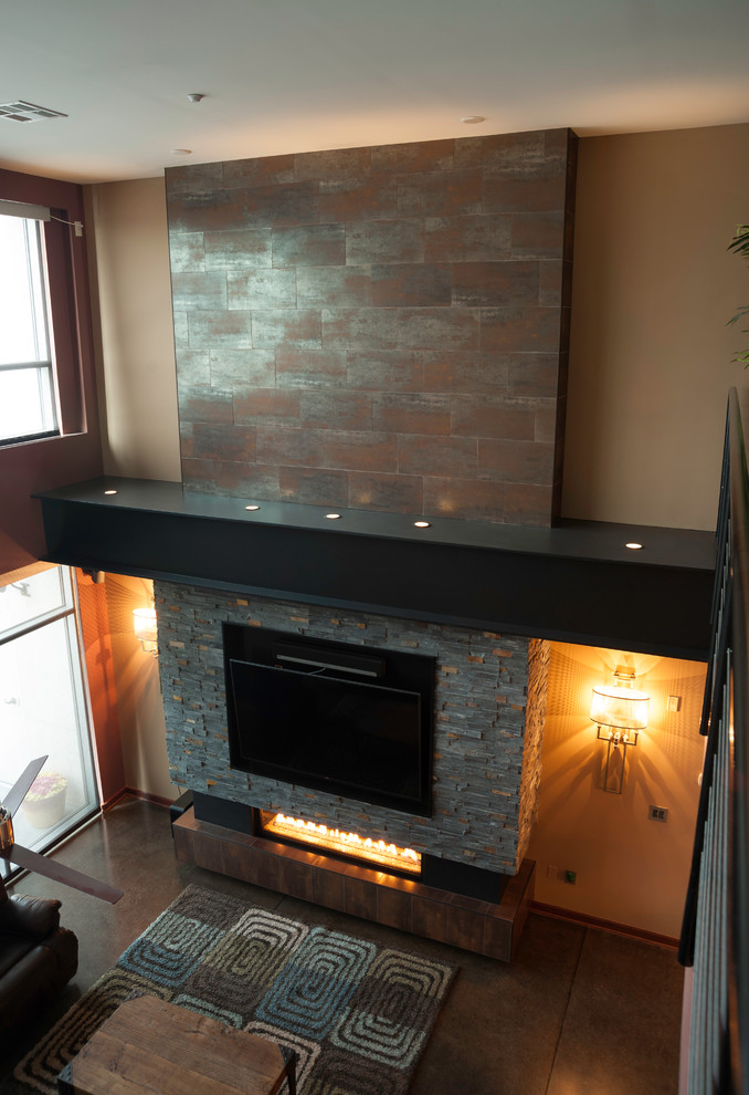 ウィチタにある高級な広いインダストリアルスタイルのおしゃれなリビング (ベージュの壁、コンクリートの床、横長型暖炉、金属の暖炉まわり、壁掛け型テレビ) の写真