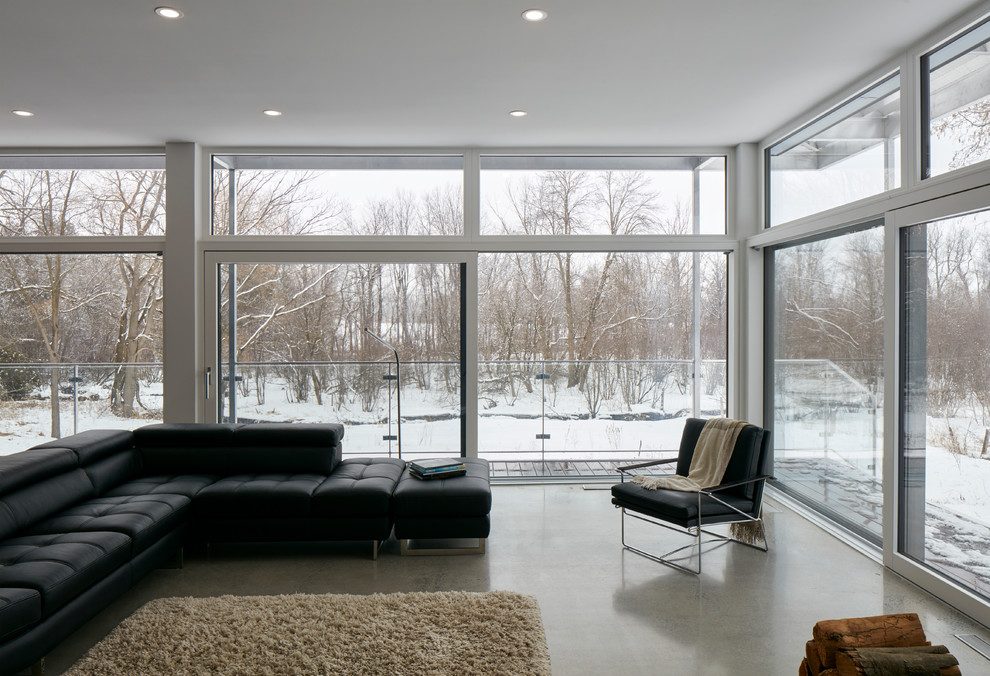 На фото: огромная открытая гостиная комната в стиле лофт с белыми стенами, бетонным полом, печью-буржуйкой, фасадом камина из металла и серым полом