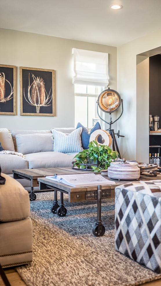 Mittelgroßes, Offenes Industrial Wohnzimmer mit beiger Wandfarbe, braunem Holzboden und freistehendem TV in San Diego