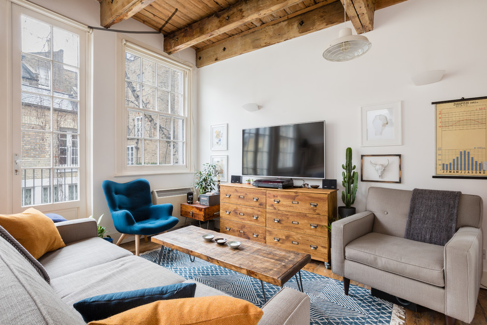 Offenes Industrial Wohnzimmer mit weißer Wandfarbe, braunem Holzboden, TV-Wand und braunem Boden in London