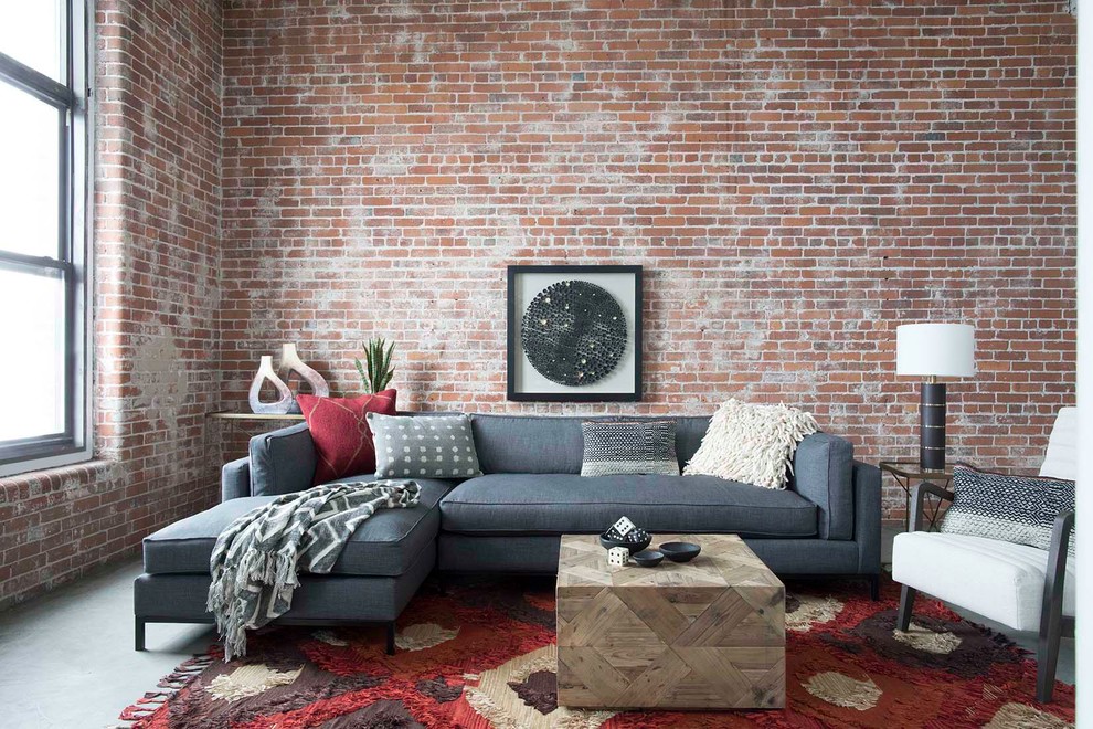 Immagine di un soggiorno industriale con pareti rosse, pavimento in cemento, nessun camino e tappeto