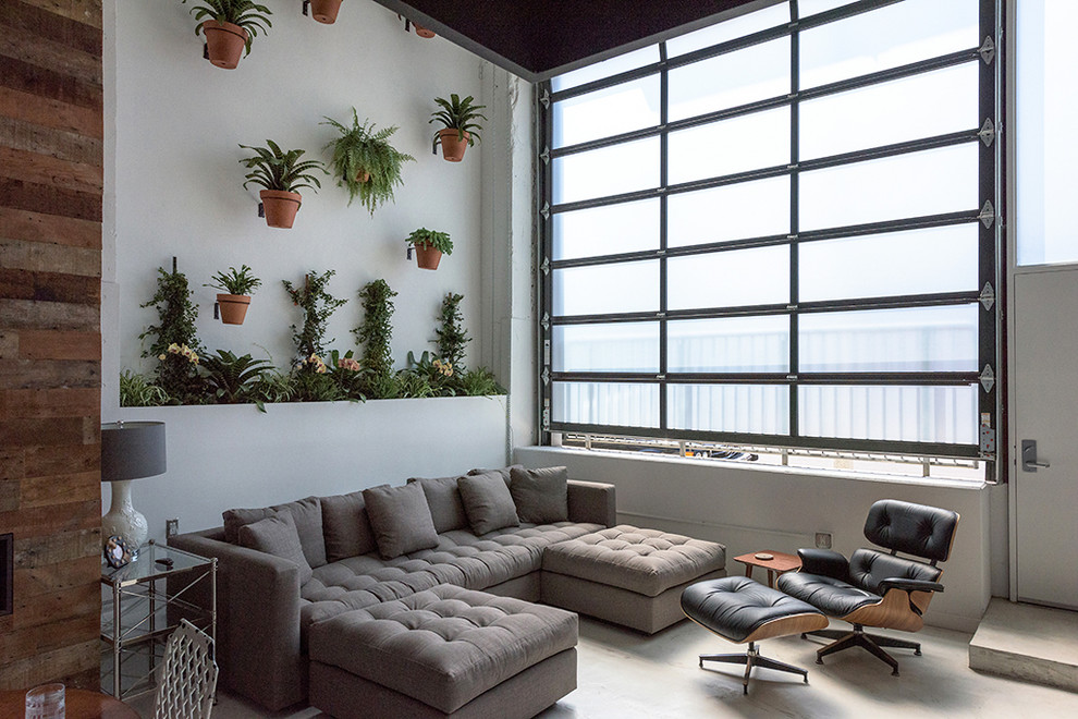 Inspiration for an industrial formal and open concept concrete floor living room remodel in Los Angeles with white walls