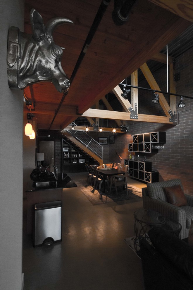 Esempio di un soggiorno industriale stile loft con pavimento in cemento e TV a parete