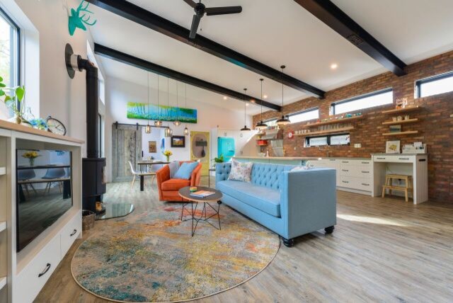 Foto di un grande soggiorno eclettico stile loft con pareti bianche, pavimento in vinile, stufa a legna, cornice del camino piastrellata, parete attrezzata e pavimento grigio