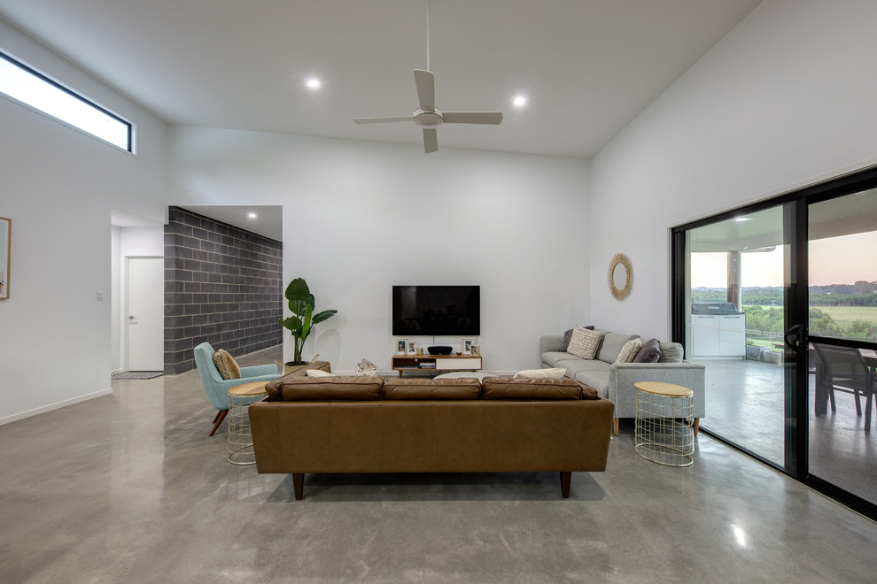 サンシャインコーストにあるインダストリアルスタイルのおしゃれなLDK (白い壁、コンクリートの床、壁掛け型テレビ、グレーの床) の写真