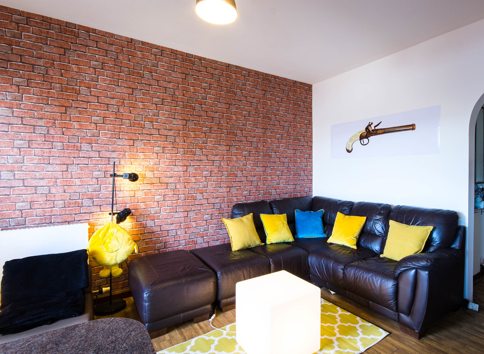 Aménagement d'un petit salon industriel ouvert avec un mur multicolore, sol en stratifié, un téléviseur indépendant et un sol marron.