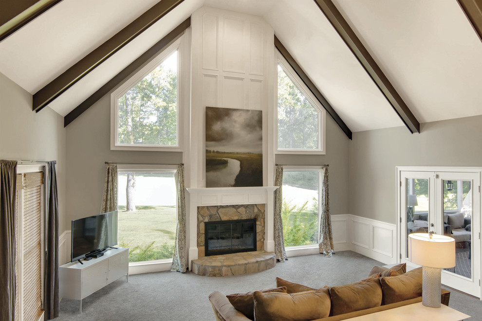 トラディショナルスタイルのおしゃれなLDK (ベージュの壁、カーペット敷き、標準型暖炉、レンガの暖炉まわり、グレーの床) の写真