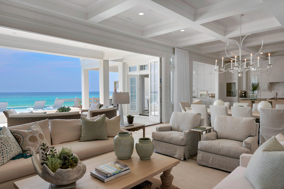 Design ideas for an expansive beach style open plan living room in Miami with white walls, travertine flooring, a standard fireplace, a tiled fireplace surround, a wall mounted tv and feature lighting.