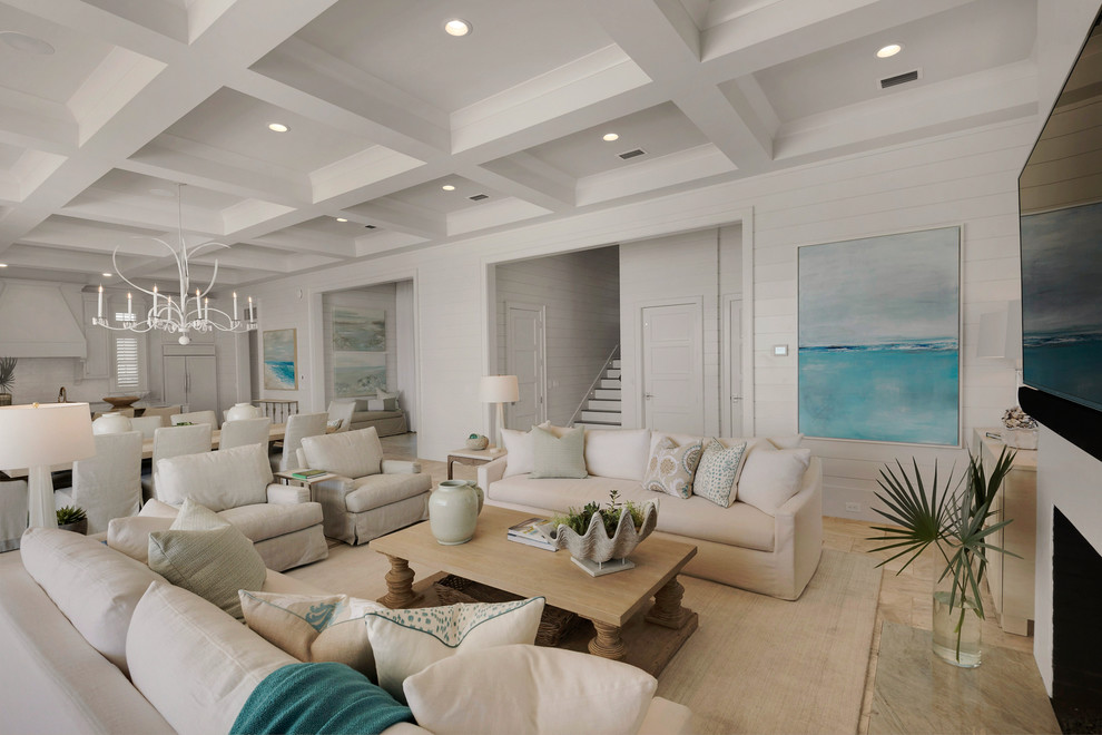 Свежая идея для дизайна: огромная открытая гостиная комната:: освещение в морском стиле с белыми стенами, стандартным камином, фасадом камина из плитки, телевизором на стене и полом из травертина - отличное фото интерьера