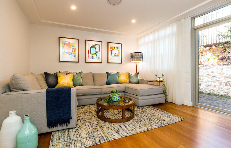 Idee per un soggiorno moderno di medie dimensioni e chiuso con pareti bianche, pavimento in legno massello medio, TV a parete e pavimento marrone