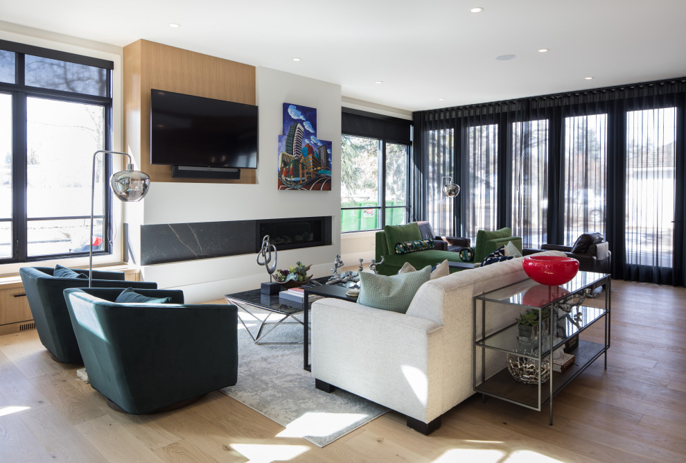 Großes, Repräsentatives, Offenes Modernes Wohnzimmer mit weißer Wandfarbe, hellem Holzboden, Kamin, TV-Wand und schwarzem Boden in Calgary
