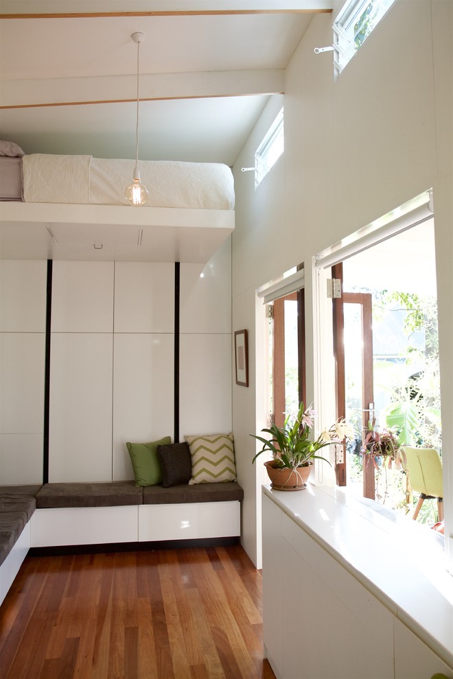Fernseherloses, Offenes Modernes Wohnzimmer ohne Kamin mit weißer Wandfarbe und dunklem Holzboden in Brisbane