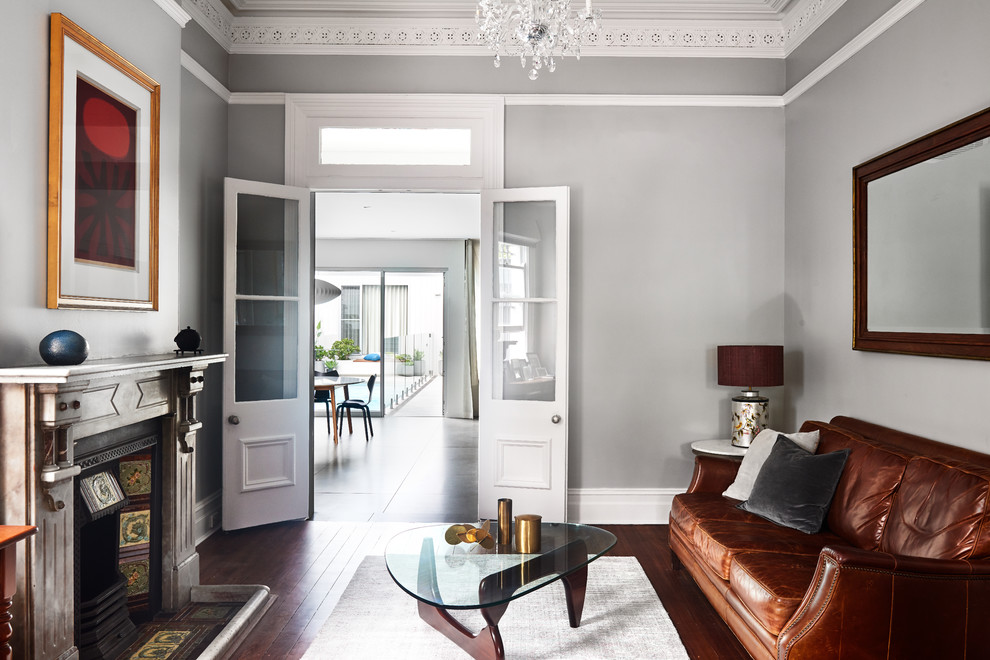 На фото: гостиная комната в стиле неоклассика (современная классика) с серыми стенами, паркетным полом среднего тона, стандартным камином и коричневым полом
