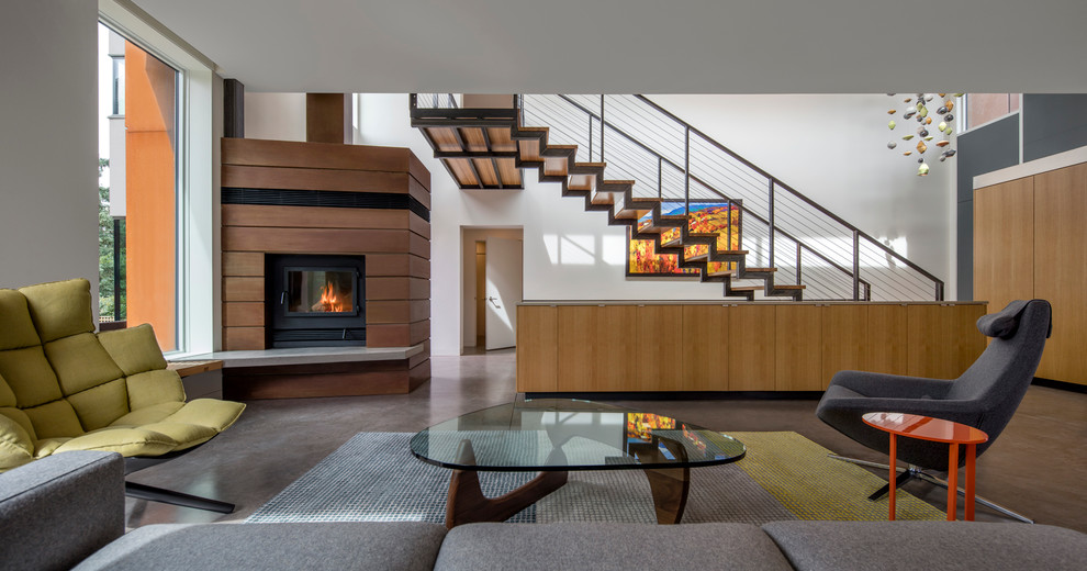 Источник вдохновения для домашнего уюта: парадная, открытая гостиная комната в стиле модернизм с белыми стенами, бетонным полом, угловым камином, фасадом камина из дерева и серым полом
