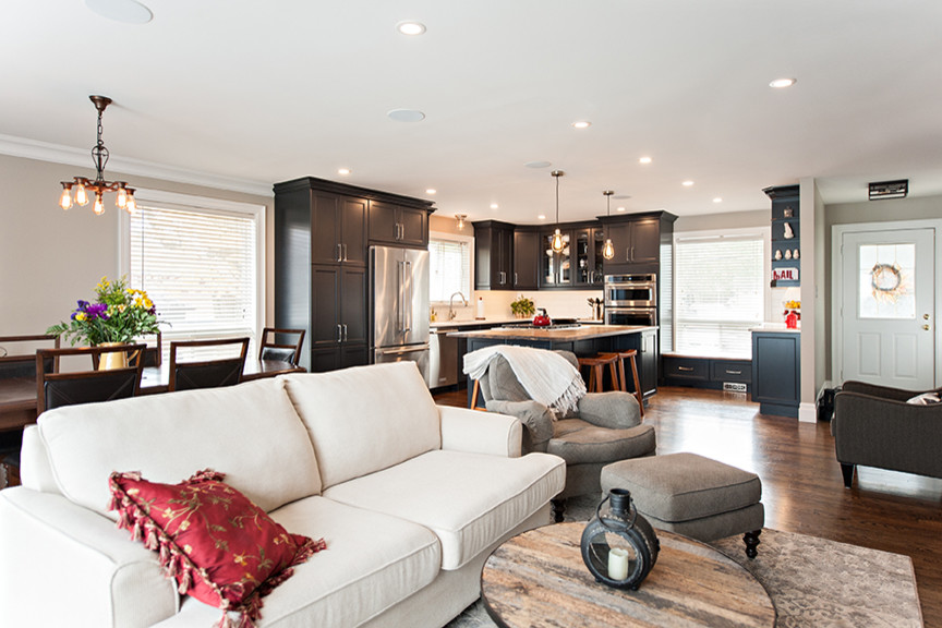 Esempio di un soggiorno minimalista di medie dimensioni e aperto con pareti beige, parquet chiaro, stufa a legna e cornice del camino in mattoni