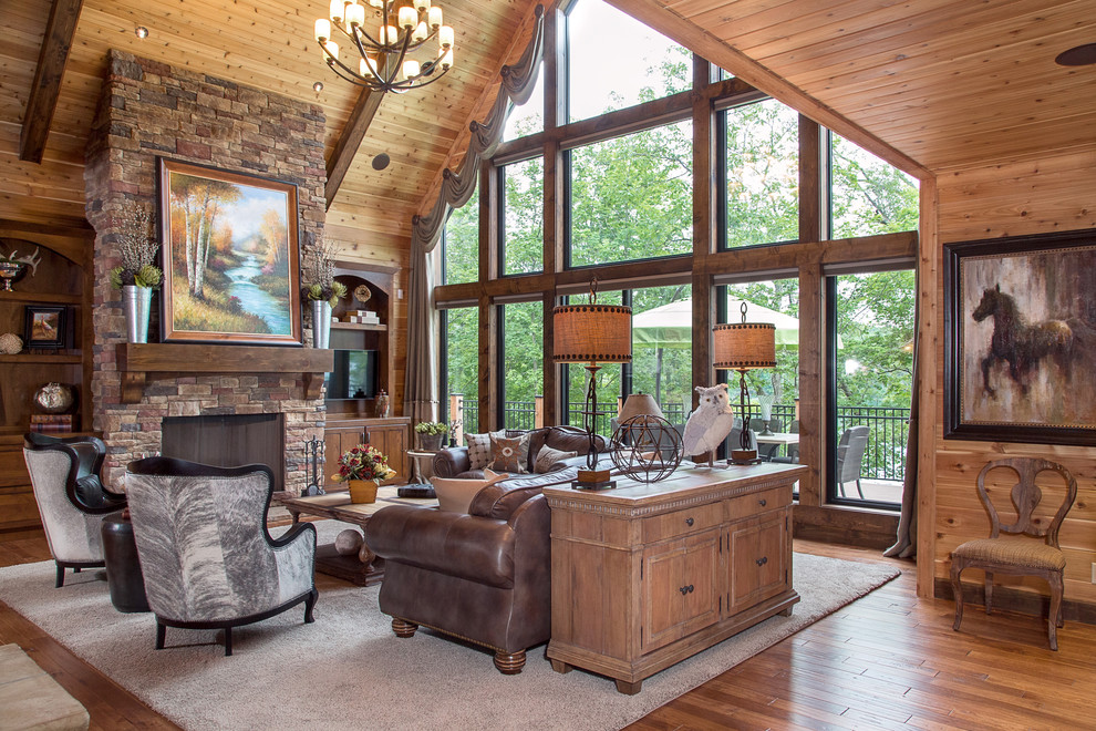 Example of a mountain style formal medium tone wood floor living room design in St Louis with a standard fireplace and a stone fireplace