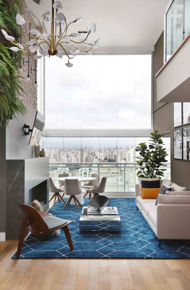 Foto di un soggiorno design aperto con pareti grigie, parquet chiaro e pavimento beige