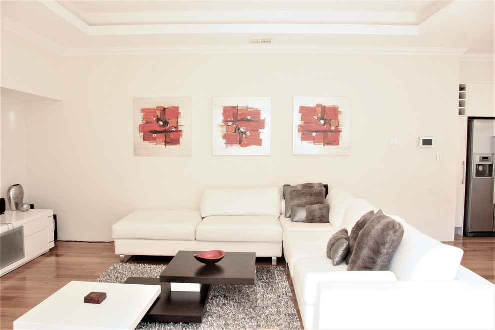 Inspiration pour un salon minimaliste de taille moyenne et ouvert avec une salle de réception, un mur blanc, un sol en bois brun, un téléviseur fixé au mur et un sol jaune.