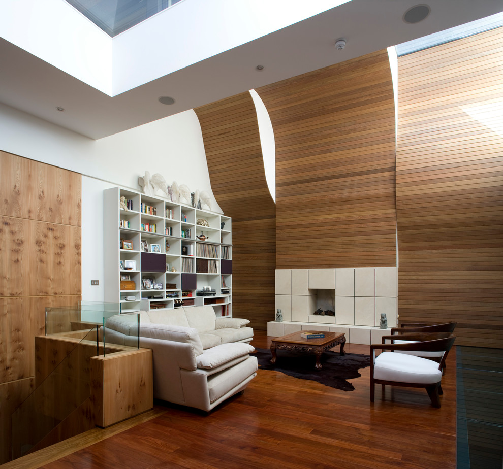 Cette image montre un salon design ouvert avec un sol en bois brun et une cheminée standard.