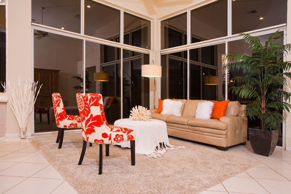 マイアミにある低価格の広いトロピカルスタイルのおしゃれなLDK (ベージュの壁、セラミックタイルの床、暖炉なし、内蔵型テレビ、白い床) の写真