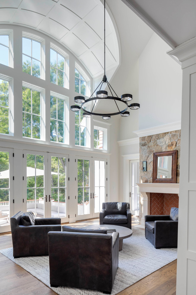 Großes, Fernseherloses Klassisches Wohnzimmer im Loft-Stil mit grauer Wandfarbe, braunem Holzboden, Kamin, Kaminumrandung aus Stein und braunem Boden in Boston
