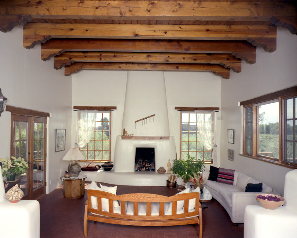 Пример оригинального дизайна: большая открытая гостиная комната в стиле фьюжн с кирпичным полом, стандартным камином и фасадом камина из штукатурки