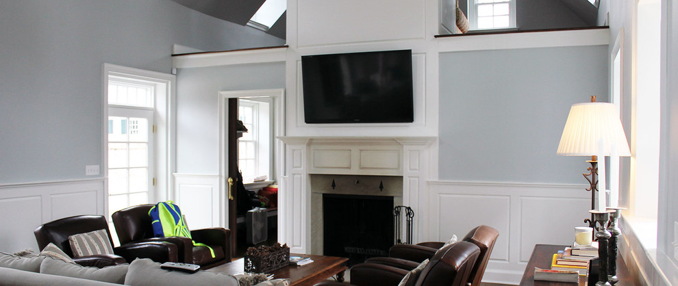 Foto på ett mellanstort vintage separat vardagsrum, med blå väggar, mellanmörkt trägolv, en standard öppen spis, en väggmonterad TV och en spiselkrans i trä