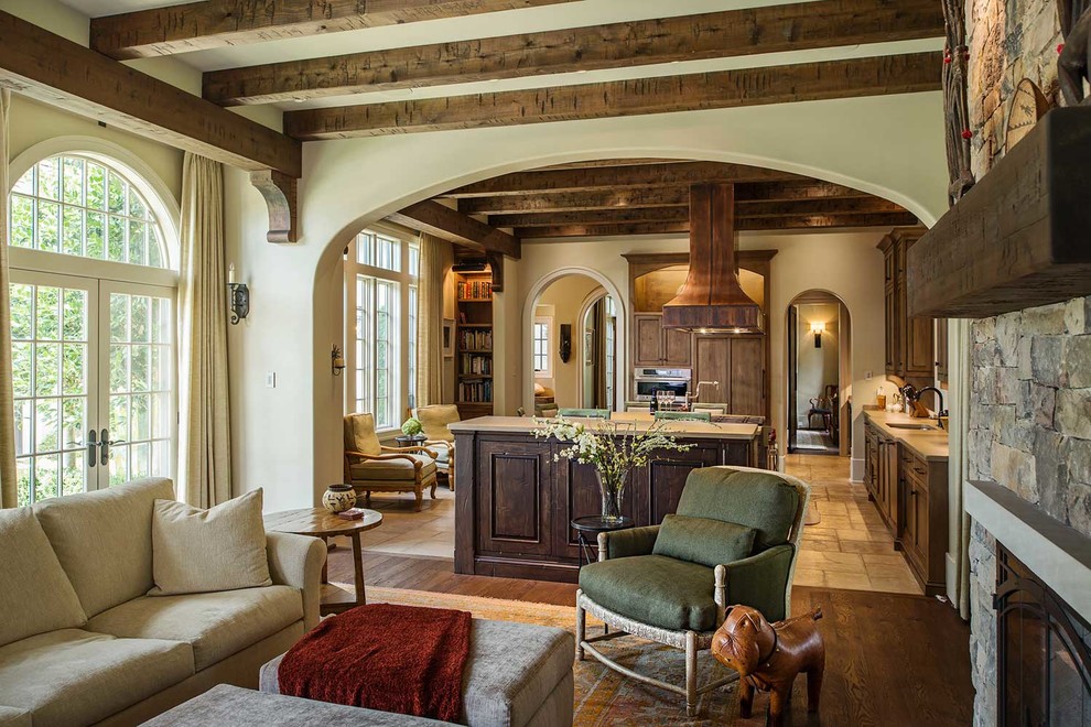 Inspiration for a mid-sized rustic formal and open concept medium tone wood floor living room remodel in Orange County with beige walls, a standard fireplace, a stone fireplace and no tv