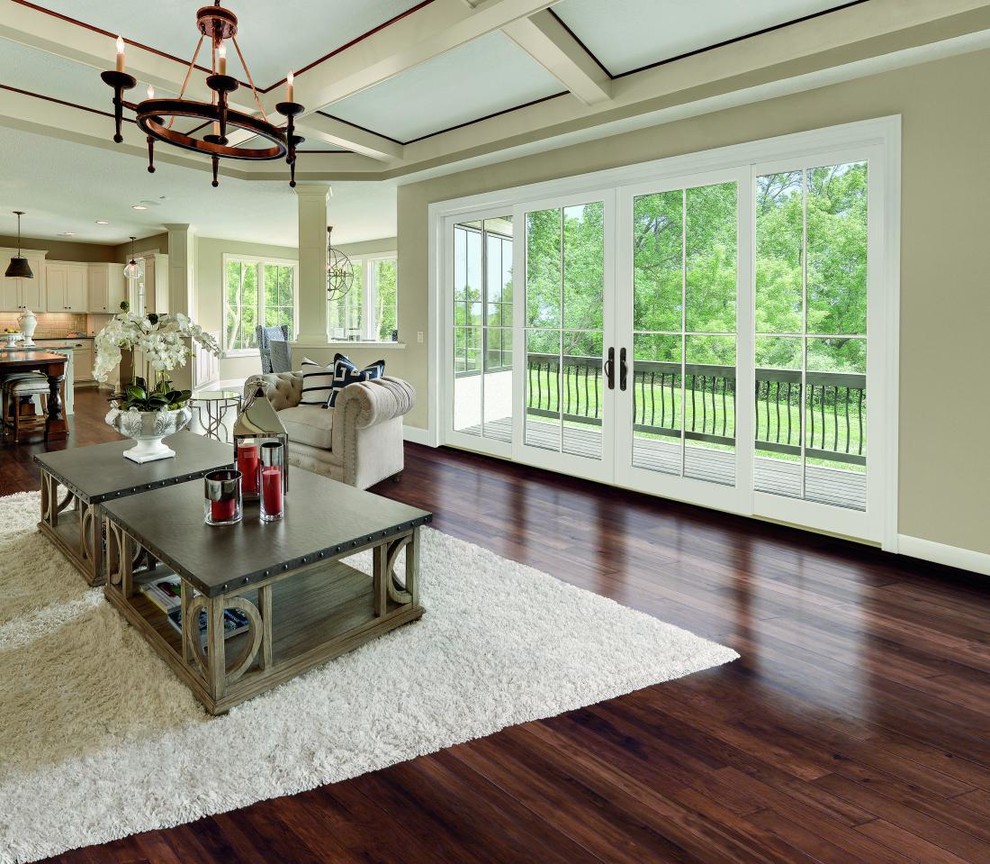 Modelo de salón para visitas abierto minimalista grande con paredes beige, suelo de madera oscura y suelo marrón