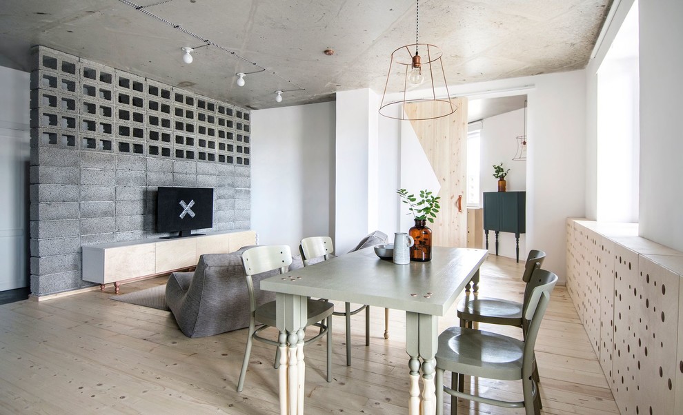Cette image montre une petite salle à manger urbaine avec un mur blanc et un sol en bois brun.