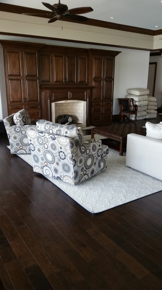 Esempio di un soggiorno tradizionale con pareti bianche, parquet scuro, camino classico e cornice del camino in legno