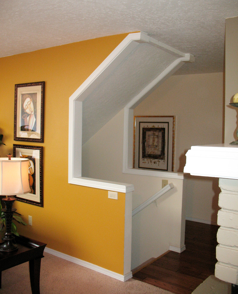Ejemplo de salón campestre con paredes amarillas, moqueta, chimenea de esquina y marco de chimenea de ladrillo