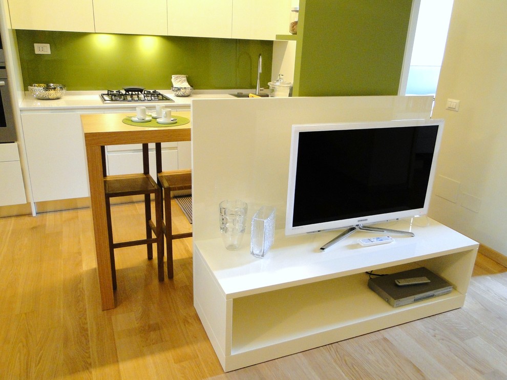 Imagen de salón con barra de bar abierto actual pequeño con paredes blancas, suelo de madera en tonos medios, televisor independiente y suelo marrón