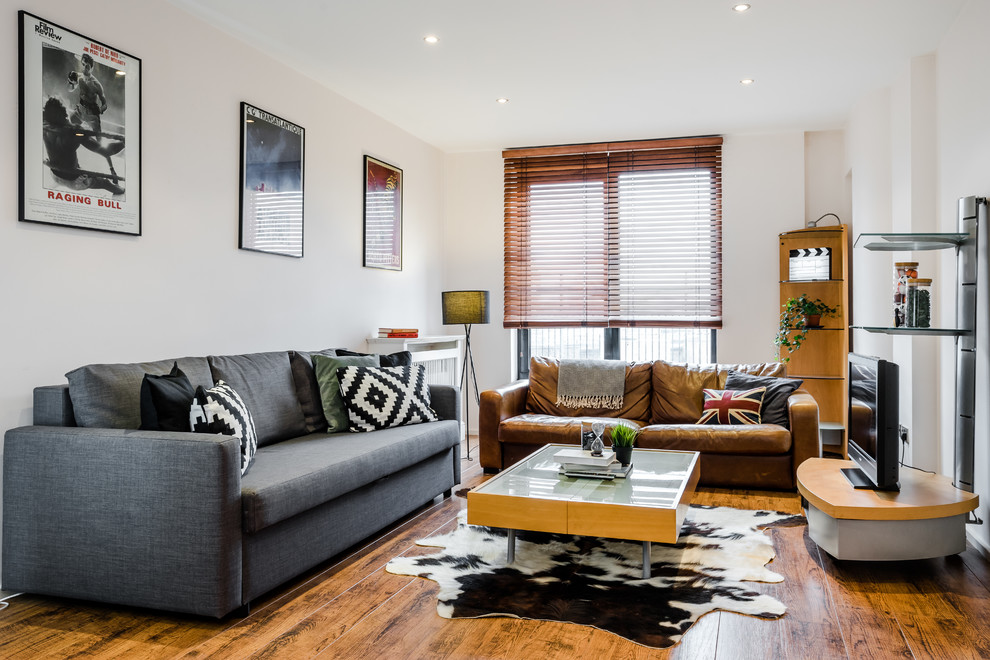 Foto di un soggiorno design con pareti beige, parquet chiaro e TV autoportante