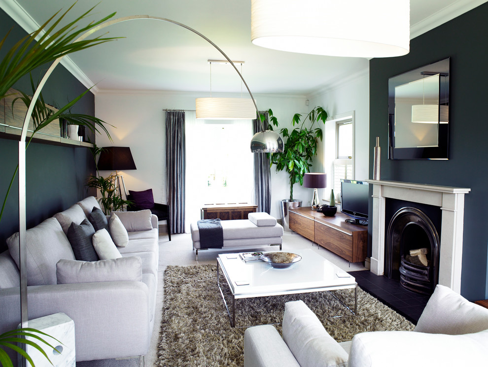 Foto de salón abierto actual de tamaño medio con paredes grises, marco de chimenea de madera y televisor independiente