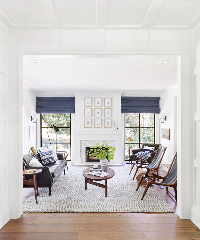 Abgetrenntes Klassisches Wohnzimmer mit weißer Wandfarbe, braunem Holzboden, Kamin, Kaminumrandung aus Stein und braunem Boden in Portland Maine