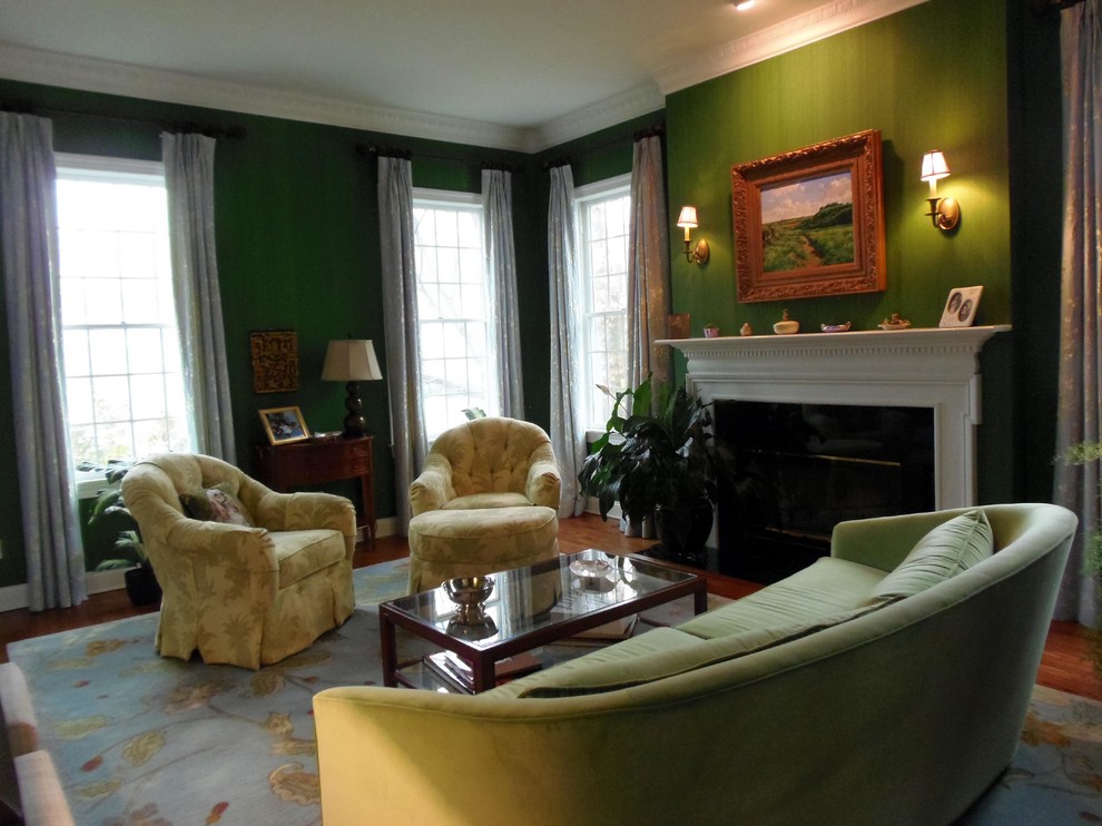 Immagine di un soggiorno chic con pareti verdi, pavimento in legno massello medio e camino classico
