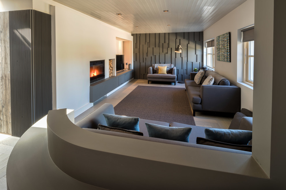 Идея дизайна: большая парадная, открытая гостиная комната в скандинавском стиле с белыми стенами, стандартным камином, фасадом камина из дерева и отдельно стоящим телевизором