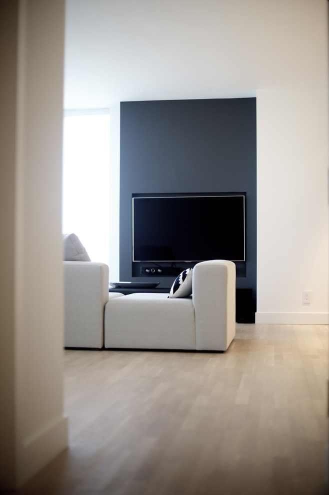 Living room - small modern enclosed light wood floor living room idea in Vancouver with white walls and a media wall