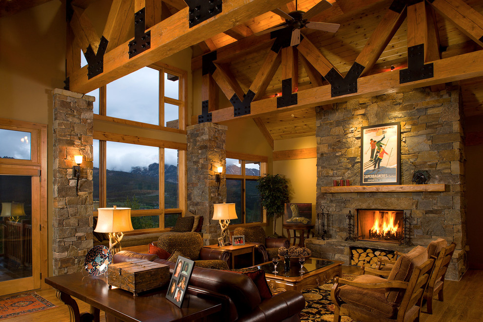 Photo of a medium sized rustic formal enclosed living room in Other with brown walls, medium hardwood flooring, a standard fireplace, a stone fireplace surround, no tv and brown floors.