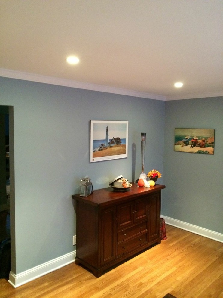 This is an example of a nautical enclosed living room in New York with blue walls and light hardwood flooring.