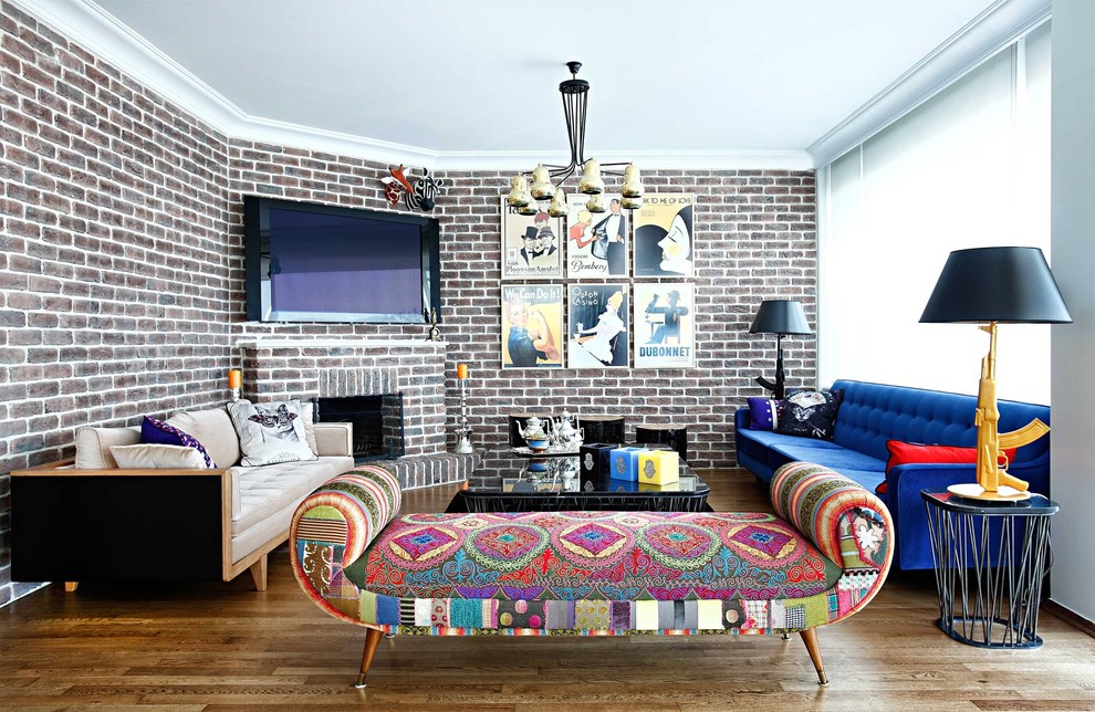 Стильный дизайн: гостиная комната в стиле фьюжн с угловым камином и синим диваном - последний тренд