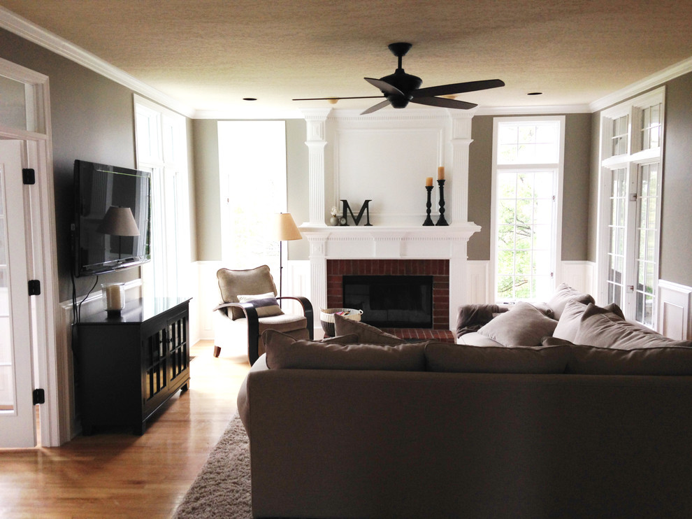 Exempel på ett mellanstort klassiskt separat vardagsrum, med ett finrum, beige väggar, mellanmörkt trägolv, en standard öppen spis, en spiselkrans i tegelsten och en väggmonterad TV